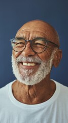 Obraz premium Smiling Old Man with a Beard in a White Shirt and Glasses, Against a Blue Background.
