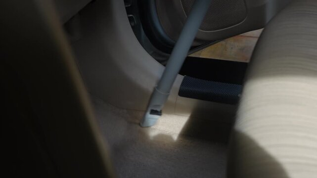People using vacuum cleaner to clean mpv car interior, warn morning light, natural background