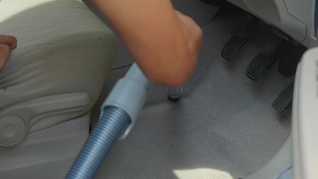 People using vacuum cleaner to clean mpv car interior, warn morning light, natural background