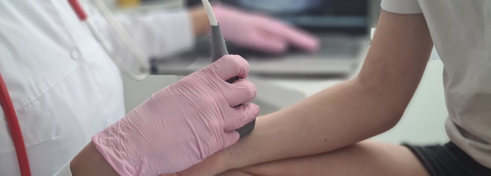 Doctor conducts ultrasound examination of patient child wrist