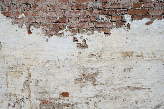 Old brick wall background with damaged plaster and exposed bricks, distressed urban texture detail, no person 