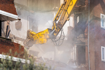 Demolition of brick building with excavator arm © MarshallChan