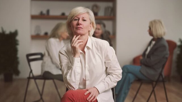 Joyful blonde woman looking at camera, participant of group therapy for ladies. Psychological rehabilitation for victims of domestic violence or divorced women, empowered lady looking at camera