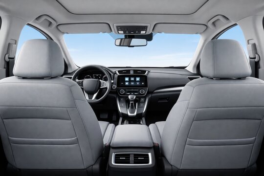 Inside View of a Modern Vehicle's Interior: Offering a perspective on sophisticated automobile design, it presents a view from the back seat showcasing sleek lines and user-friendly technology.