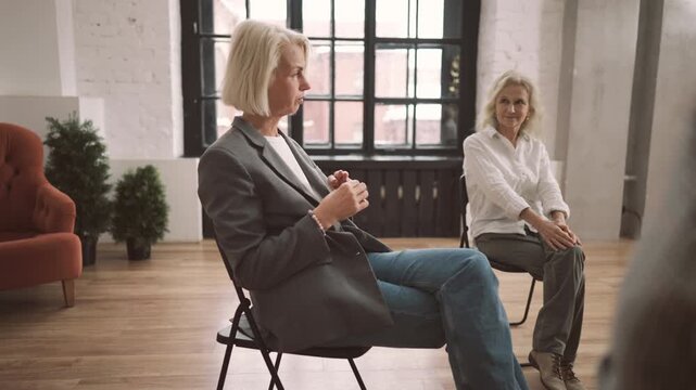 Portrait of elegant blonde woman sitting in women club or group therapy . Meeting for senior ladies for communicating and deciding life problems, aged female person speaking her life story