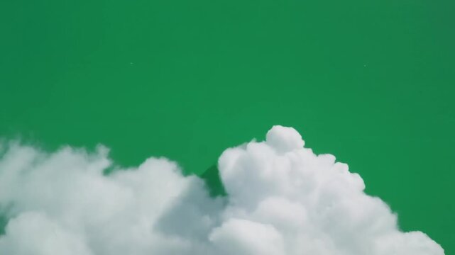 Realistic floating white cumulus clouds against a vibrant green screen background, ideal for digital compositing, visual effects, and dynamic sky replacement in creative projects with ample copy space