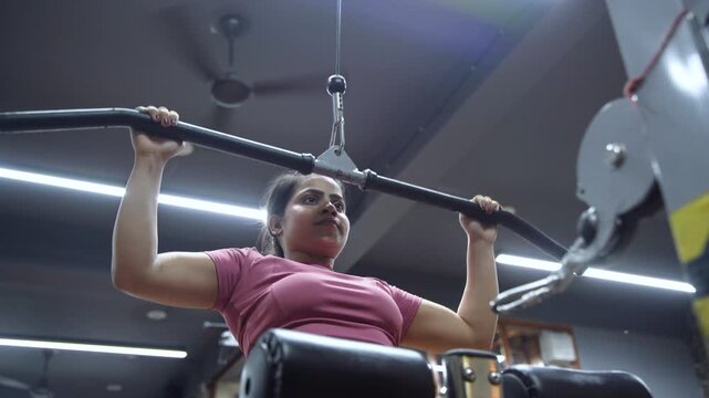 Indian Woman Performing Wide Grip Lat Pulldown Exercise for Back Workout in Modern Gym