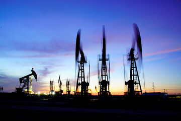Obraz premium The oil pump, industrial equipment. Oil field site, oil pumps are running.