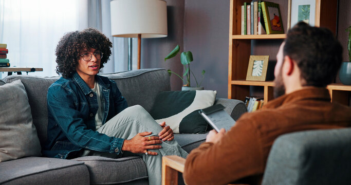 Conversation, sofa and man with therapist in office for advice, help or life coaching session. Mental health, consulting and psychologist with male patient for emotional support, wellness or talking.