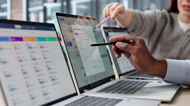 Young African American Man And Woman Use A Laptop To Calculate Payroll