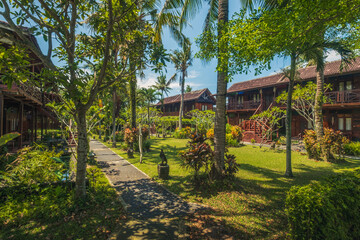 Obraz premium A comfortable and cool atmosphere with shady trees and plants at the Pondok Pitaya Inn in the Balian beach area, Tabanan, Bali, Indonesia.