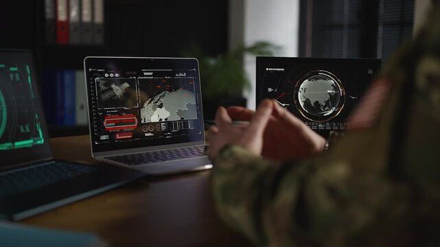 U.S. military officer monitoring missile launch on laptops, offensive simulation
