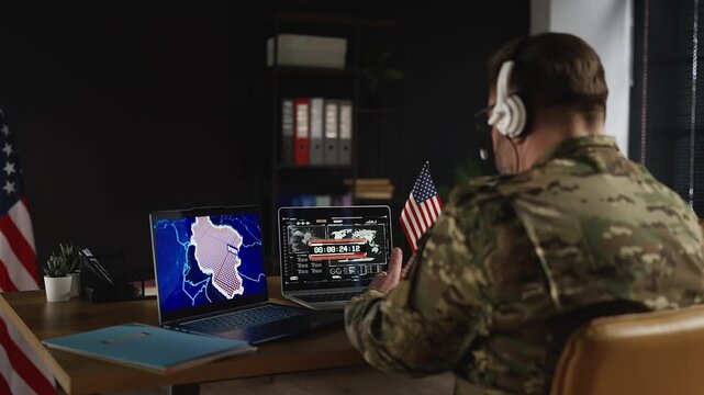U.S. military officer monitoring missile launch countdown on laptop screens