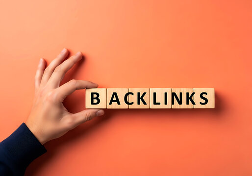 Human hand placing wooden blocks with backlinks text on orange background
