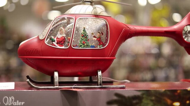 Close up of a christmas helicopter snow globe with falling snow inside festive decoration glowing lights cozy holiday atmosphere winter celebration mood