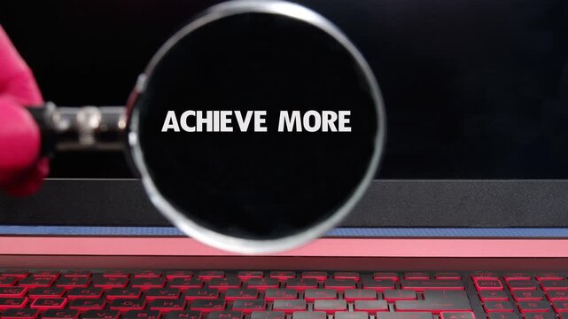 A steady hand precisely positions a magnifying glass, bringing the faint message achieve more into brilliant, sharp focus on a luminous desk surface