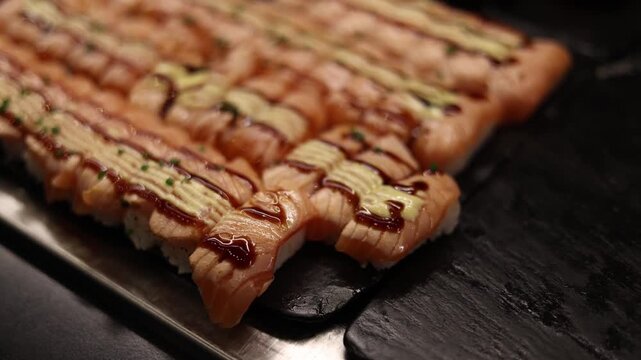 Close up of sushi rolls with salmon arranged neatly on tray highlighting texture of fish and rice in fresh seafood concept and healthy eating lifestyle