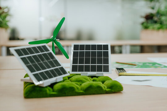 Model of solar panels and wind turbine in an office setting representing sustainable energy
