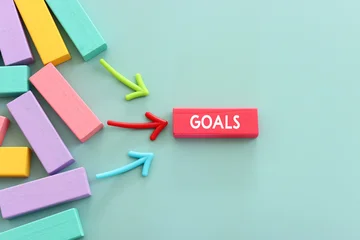 Wooden colorful cubes and the word goals on paper background. © tomertu