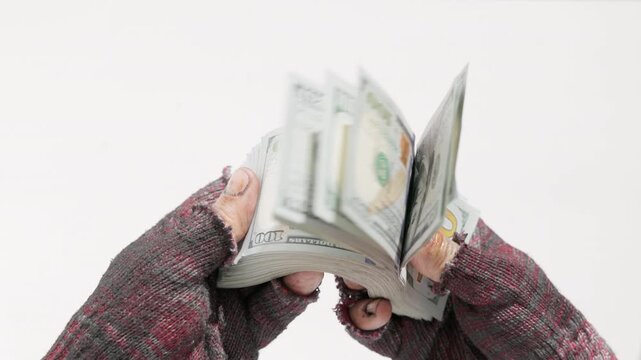 Homeless person flicking through money with bundles of US dollar cash on white background