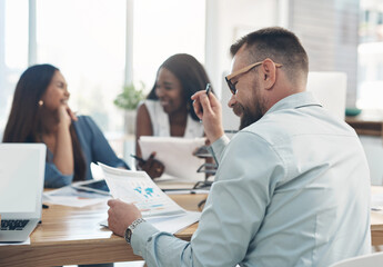 Fototapeta premium Meeting, reading and documents with business man in office for media feedback, planning or graph. Branding report, coworking and campaign chart with employees in creative agency for proposal