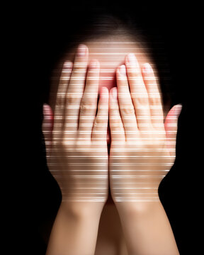 a woman's hands covering her face with digital distort lines on a black background