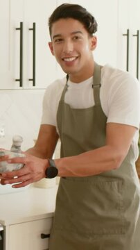 Vertical video: Showing cook olive apron in kitchen, holding mortar preparing pan as rig entering