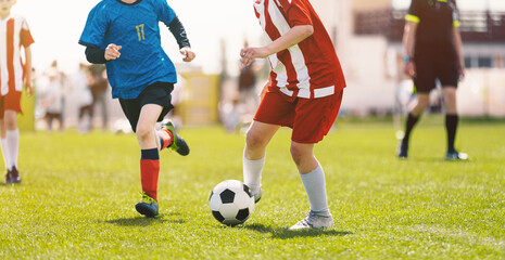 Youth Soccer Dribbling Action,  Kids Playing Football and Controlling Ball on Grass Field © matimix