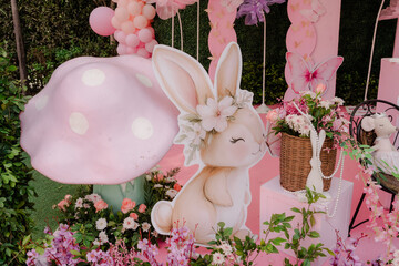 Obraz premium Charming celebration decor with an adorable bunny cutout, colorful flowers, and a large mushroom, creating a whimsical outdoor party atmosphere