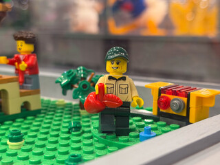 Obraz premium Lego minifigure holding red bird on green baseplate