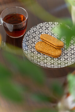 Overhead view of coffee and sandwich biscuits on a patterned plate
