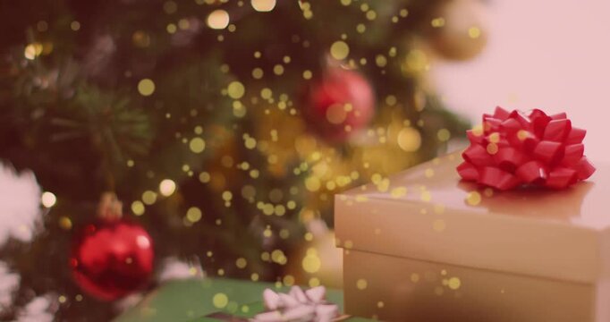 Animation of yellow spots of light falling over a decorated christmas tree and gifts