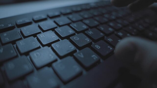 Close up on keyboard with Hebrew and English letter as hand typing on keys. Person coding or writing researching online. Pressing button and keypads. Business or dark web technology online. Desktop pc