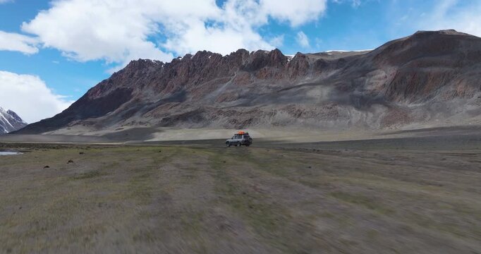 Off Road Vehicle Driving Through Tsagaan Gol Valley In Altai Mountains Of Mongolia - Drone Shot