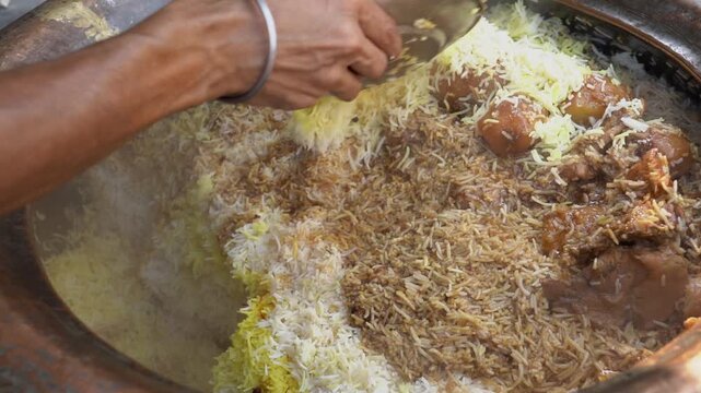 A street food vendor serves authentic Indian chicken biryani with saffron rice and potatoes from a traditional clay handi. Perfect for travel, food, and cultural documentaries.
