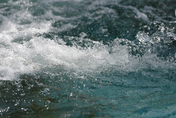 Obraz premium Close-up of water splashes with white foam on the surface, background, texture
