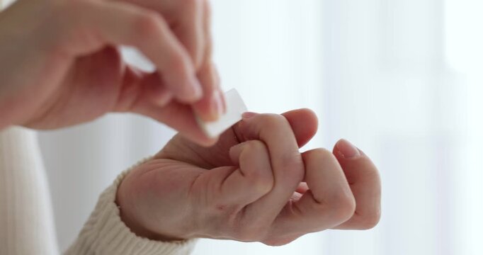 Closeup of a woman's hands using a nail file for a manicure at a white table