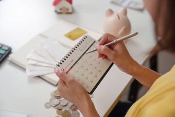 Marking financial goals on a calendar with coins and documents