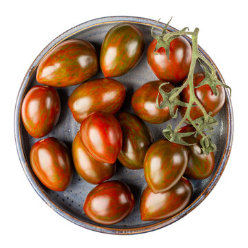 Black cherry tomatoes on gray plate isolated on white. Kumato plum tomato. Top view.