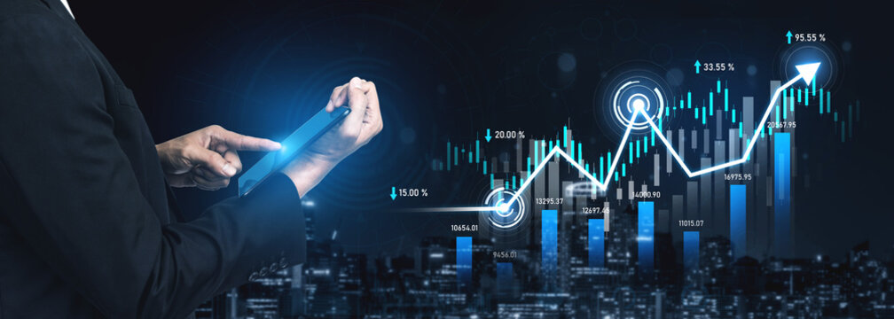 A business professional evaluates financial data on a tablet while observing upward trends displayed on a digital screen, capturing the essence of modern corporate analytics. Scalp