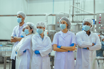 Obraz premium Processing plant workers gather in canned fish facility observing workflow and machinery performance. Image represents production oversight, quality inspection and organized factory management.