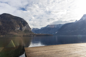 Obraz premium Wooden boat dock on alpine lake with mountains