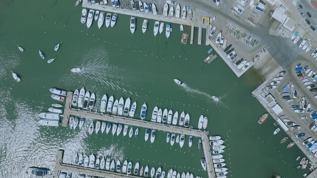 Aerial view of numerous boats docked at the port, next to the vibrant city streets, offering a striking contrast of textures and tones, Punta del Este, Departamento de Maldonado, Uruguay.