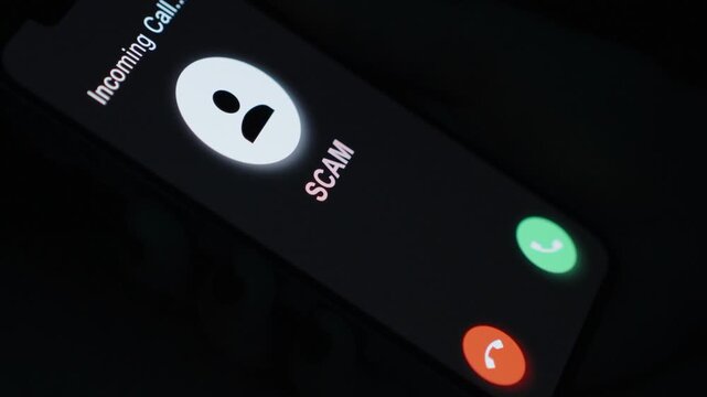 Zoom, A hand holds a phone displaying a "SCAM" call notification, urging users to be vigilant against potential fraud.