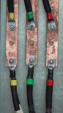 Electrical busbar connections showing three-phase power cables bolted to copper conductors inside an industrial switchgear panel.