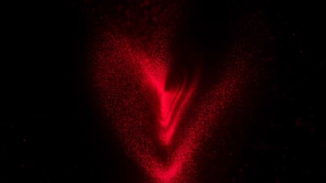 Slow motion close up of red powder plume forming swirling v shaped vortex against black background in studio with fine particles dispersing and settling
