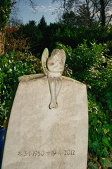 kleiner Engel hockt auf einem Grabstein auf einem Friedhof in Ratingen © Blende8