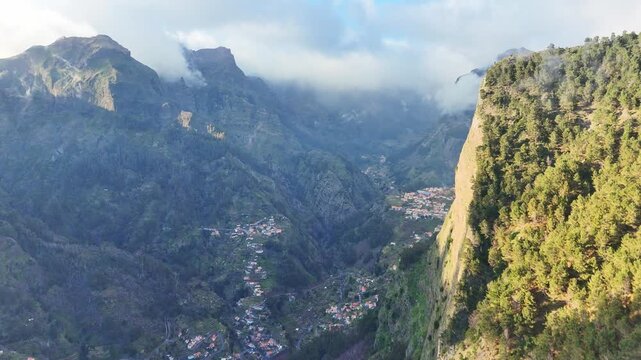 Portugal, Madeira, Curral das Freiras, Eira do Serrado. Thick mist rolls over the jagged volcanic peaks to reveal a secluded village nestled deep within the central mountains of Madeira. 