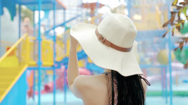 Beautiful woman tourist in bathing suit sun hat, enjoying tranquil moment swimming pool, girl relaxes in bikini soaking up sun, soak in water look around pool villa, spa water park treatments concept