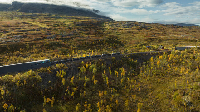 Scenic shot of coal train passing through scenic landscape at sunny day